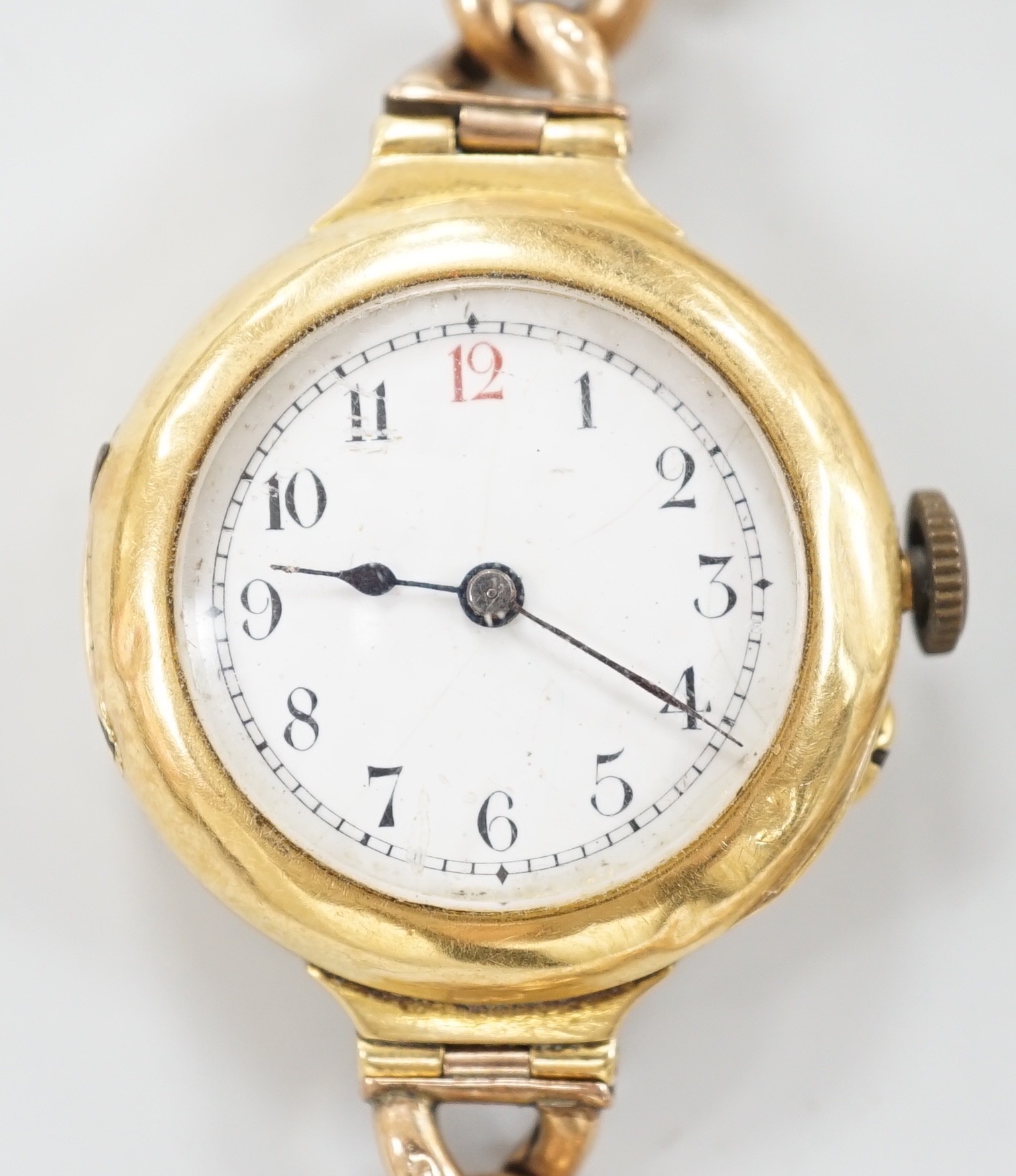 An early 20th century 18ct gold manual wind wrist watch, with Arabic dial, case diameter 27mm, on a yellow metal (stamped 15) curblink bracelet